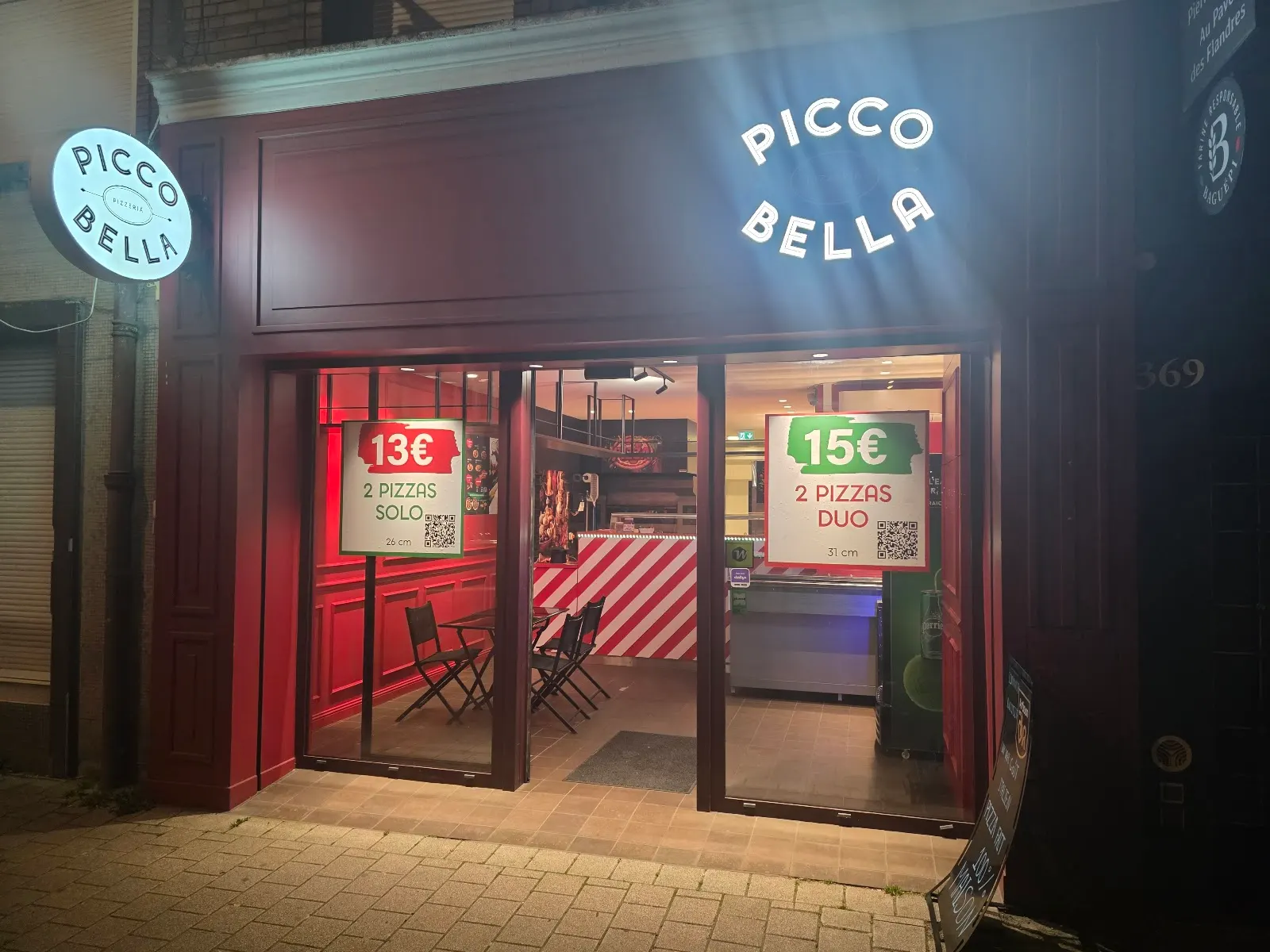La devanture bordeaux de Picco Bella, avenue de Dunkerque, éclairée le soir